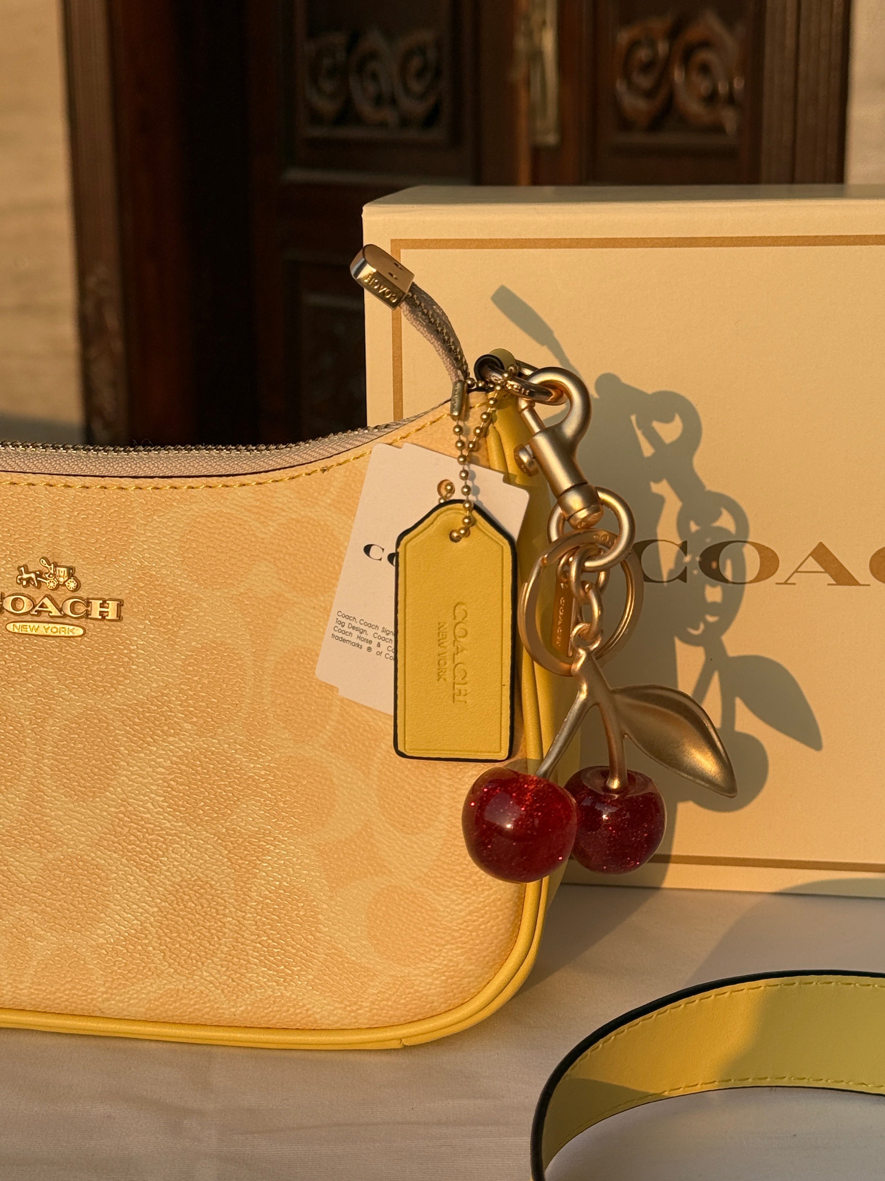 COACH LIGHT PASTEL YELLOW BAG WITH CHERRY CHARM AND 2 STRIPS