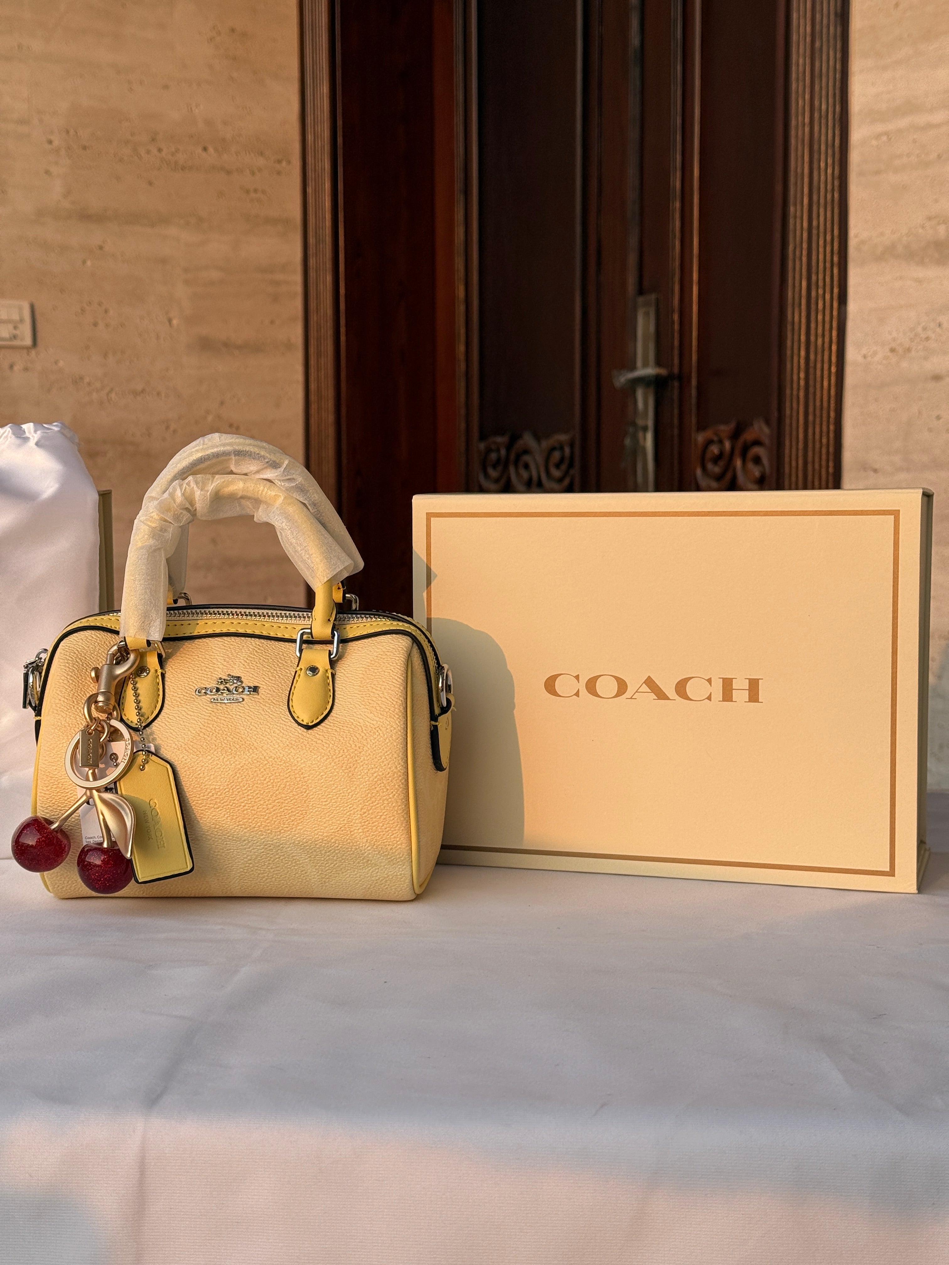COACH LIGHT PASTEL YELLOW BAG WITH CHERRY CHARM