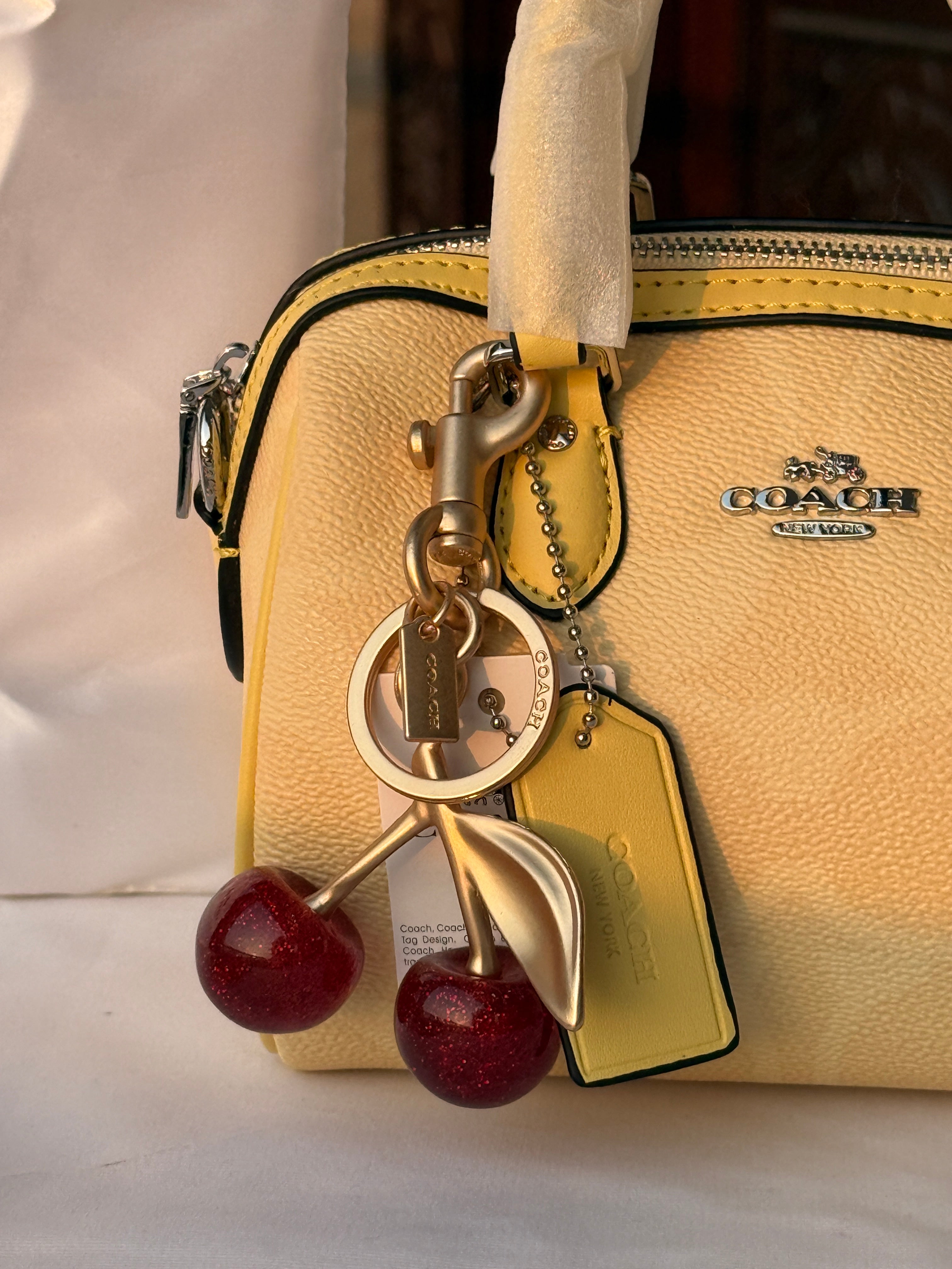 COACH LIGHT PASTEL YELLOW BAG WITH CHERRY CHARM
