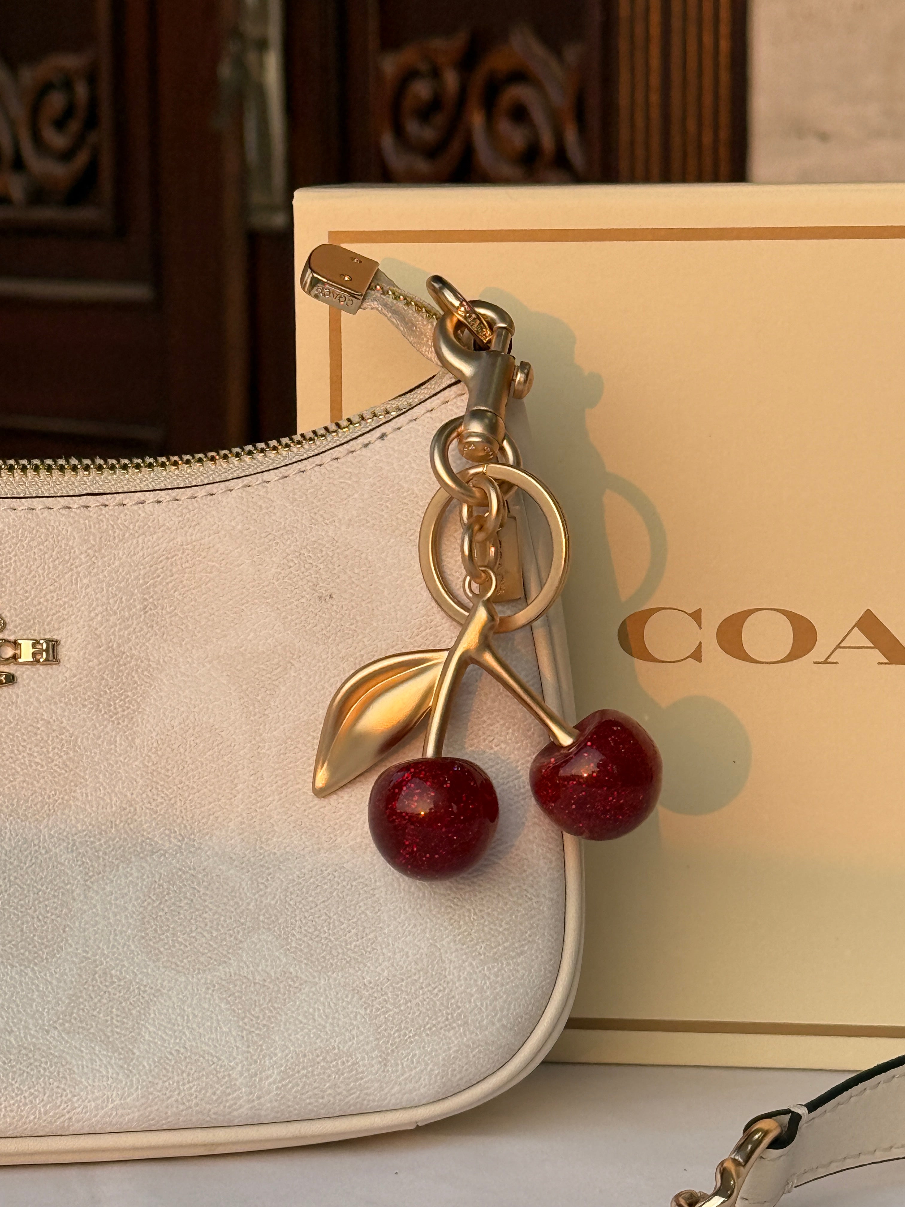 COACH WHITE PATTERN BAG WITH CHERRY CHARM AND 2 STRIPS